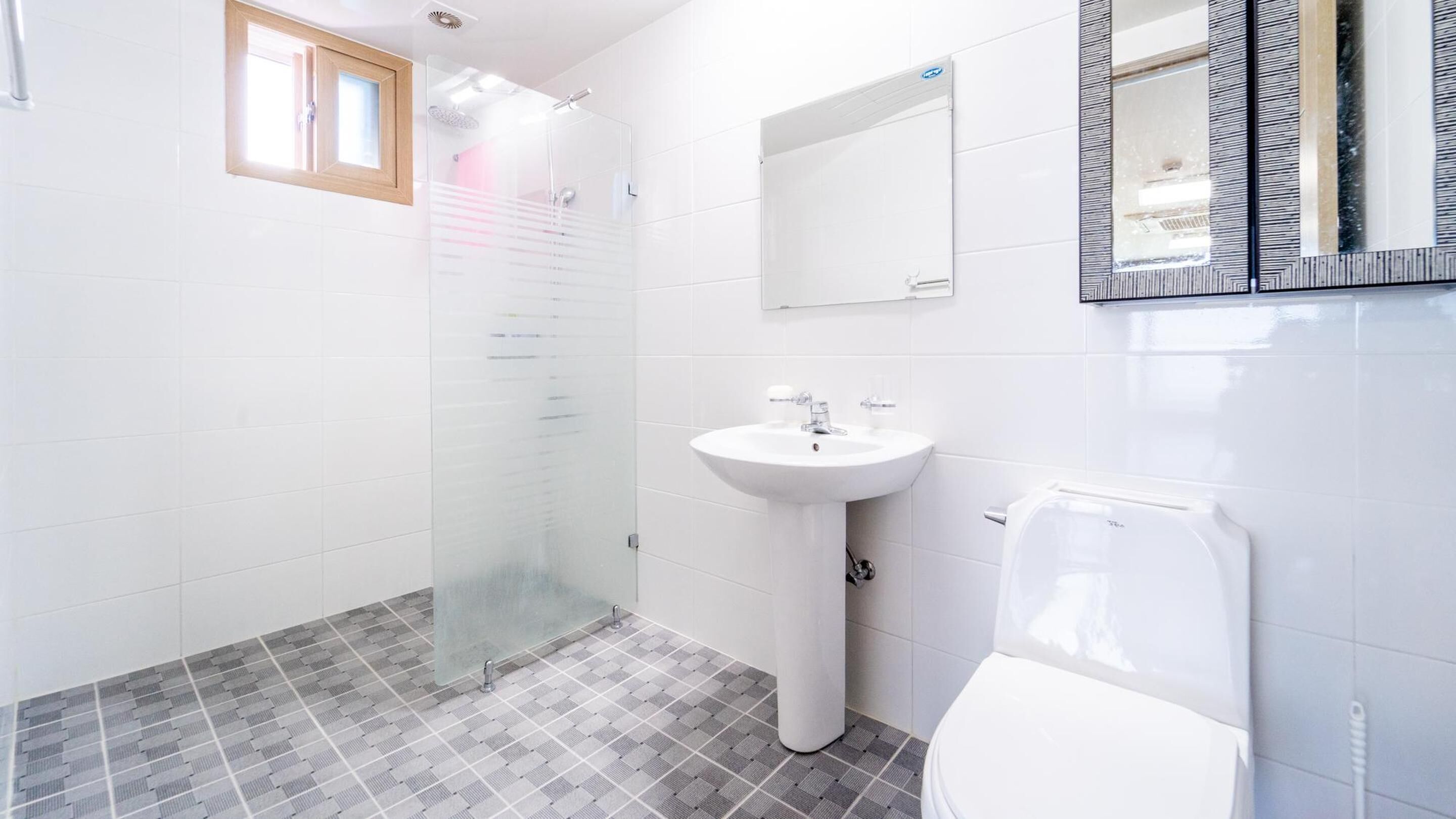 A bathroom with a shower, sink, and toilet.