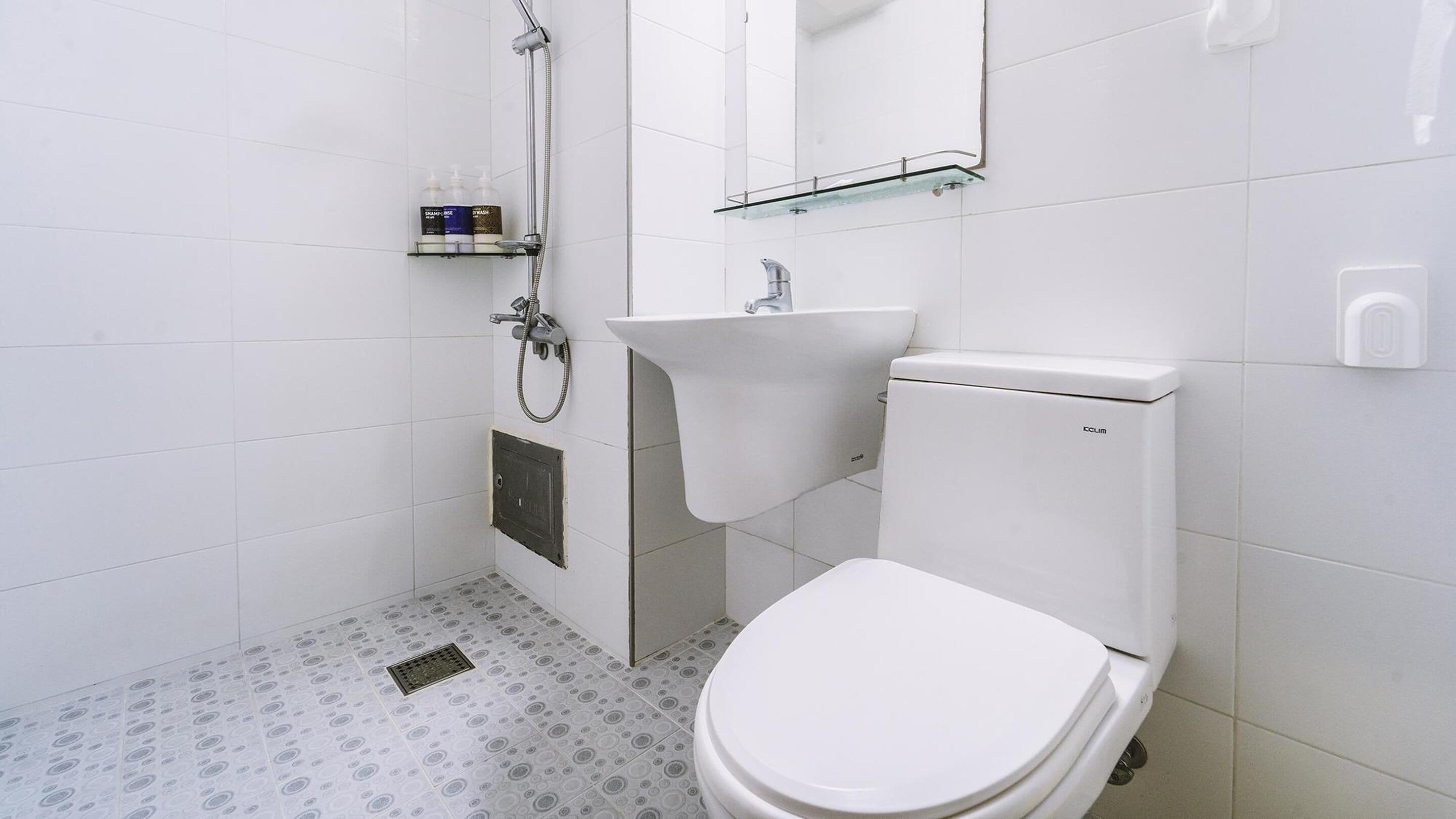 A bathroom with a toilet, sink, and shower.