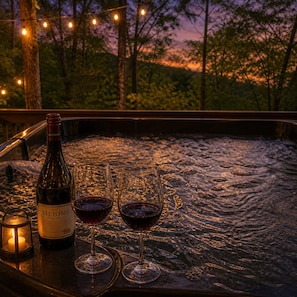 Una botella de Meomi Pinot Noir, dos copas de vino y una vela sobre una mesa con superficie texturizada.