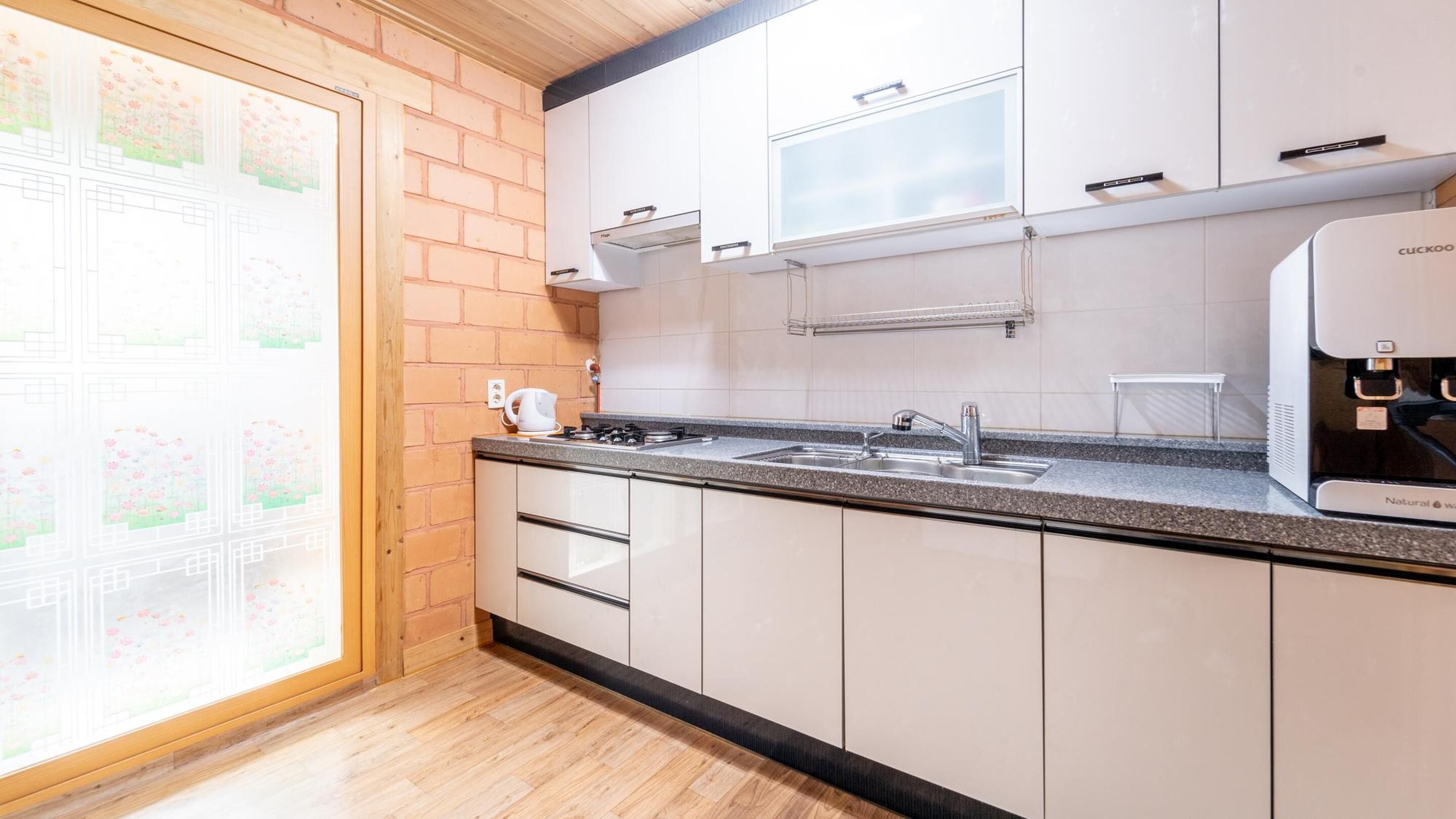 A modern kitchen with white cabinets, a granite countertop, a built-in stove, and a sink.