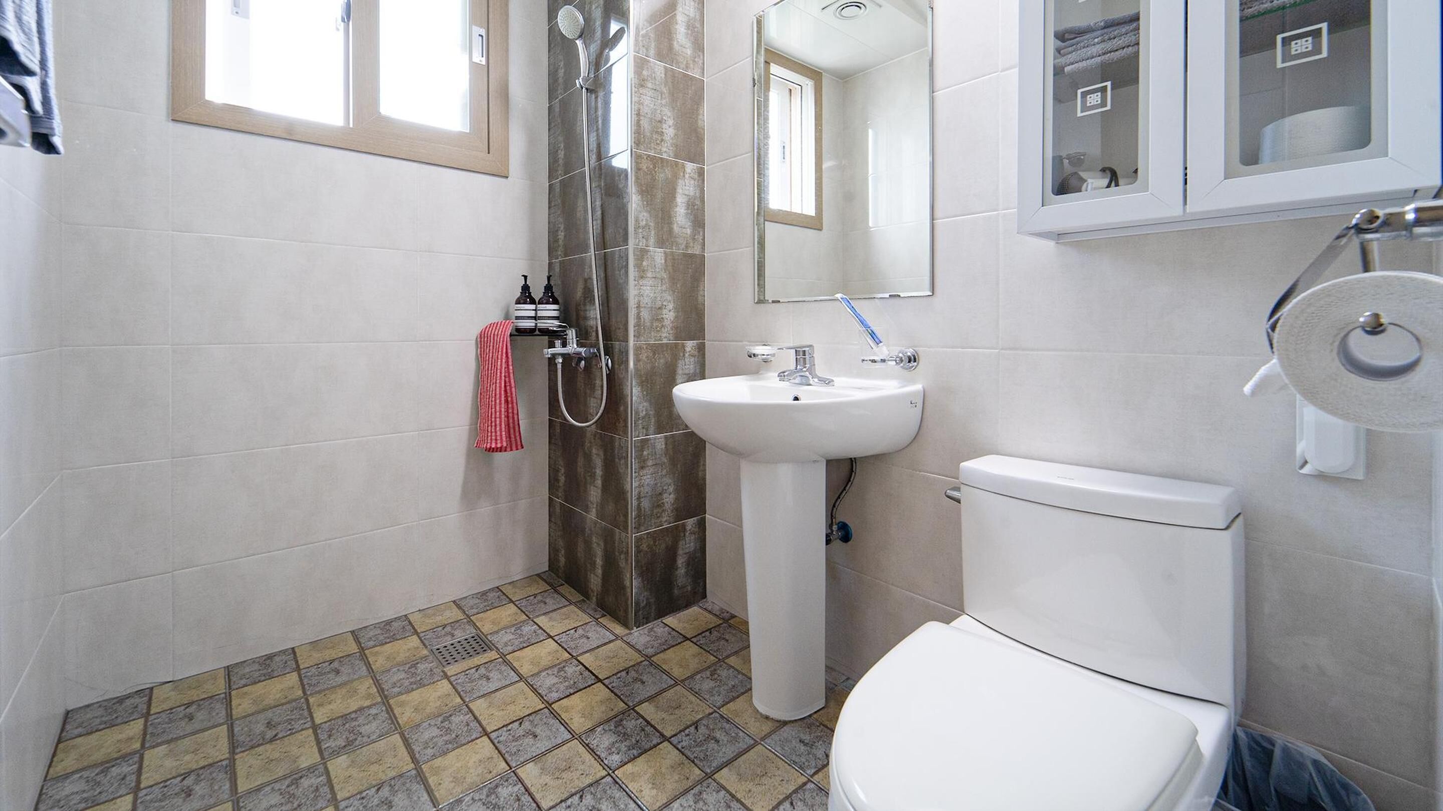 Une salle de bain avec une douche, un lavabo et des toilettes.