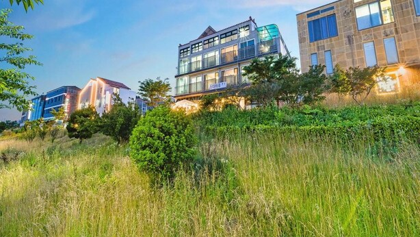 Un edifici modern amb diverses plantes, grans finestres i balcons.