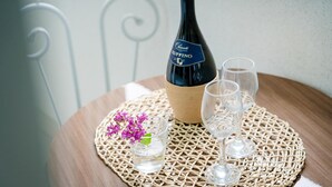 A bottle of Chianti Ruffino wine, two glasses, and a small vase with purple flowers on a woven placemat. - Samcheo Happy House Pension (Samcheok)