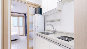 A modern kitchen with white cabinets, a stainless steel sink, and a built-in dishwasher. - Samcheo Happy House Pension (Samcheok)