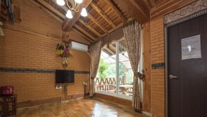 A wooden interior with a TV, a wooden door, and a window with curtains. - Gapyeong Supsokui Harmony Pension (Gapyeong)