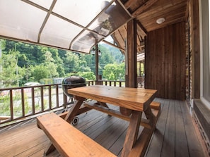 A wooden deck with a table and benches, overlooking a forested area. - Gapyeong Supsokui Harmony Pension (Gapyeong)