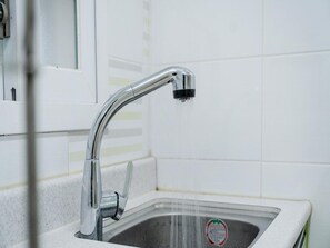 A modern kitchen sink with a chrome faucet and a soap dispenser. - Hongcheon Daebakine Pension (Hongcheon)