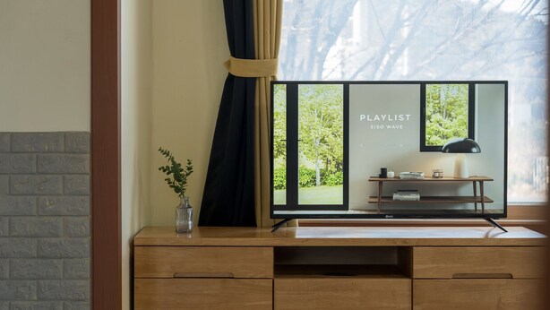 A modern room with a wooden desk, a vase with a plant, and a window with a view of greenery. - Daebudo Banditbul Pension (Ansan)