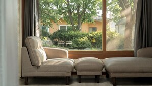 A room with a large window, two armchairs, and a small ottoman. - Daebudo Banditbul Pension (Ansan)