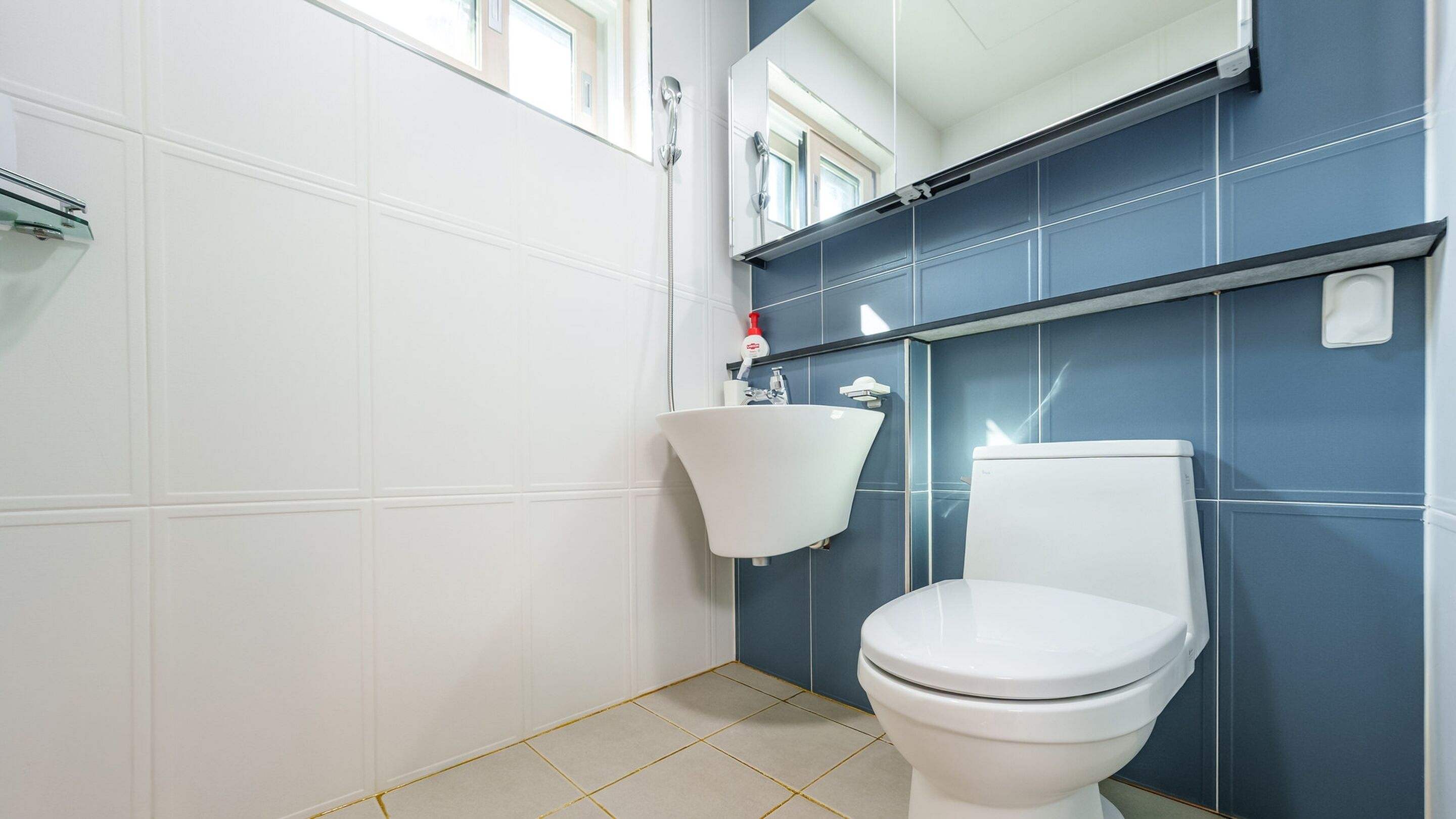 Ein Badezimmer mit Toilette, Waschbecken und einem Spiegel darüber.