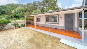 A single-story mobile home with a covered porch and a small front yard. - Samcheok Jangho Madang Minbak Pension (Samcheok)