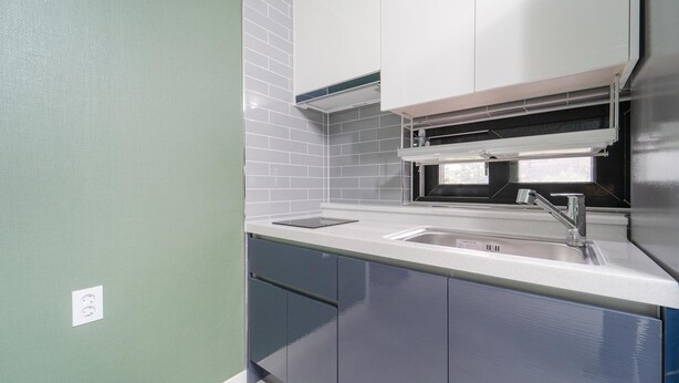 A kitchen with a sink, cabinets, and a window. - Samcheok Jangho Madang Minbak Pension (Samcheok)