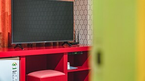 Een rode entertainmentkast met een flatscreen televisie, een geluidsinstallatie en een zithoek.