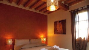 A bedroom with a bed, nightstands, and a painting on the wall. - Villa Moderna Grezzano (Grezzano)