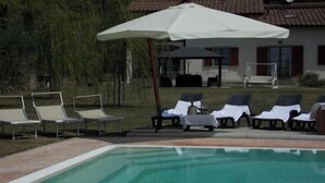 A swimming pool with lounge chairs and a covered seating area. - Villa Moderna Grezzano (Grezzano)