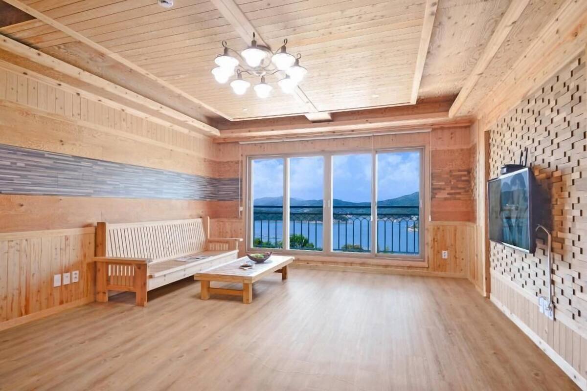 Un intérieur en bois avec un canapé, une table basse et un téléviseur fixé au mur.
