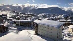 En snötäckt stad med byggnader, inklusive en framträdande vit byggnad med många fönster.