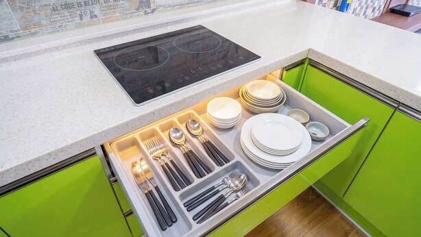 A kitchen with a built-in induction cooktop and a drawer organizer containing plates, bowls, and cutlery. - Ganghwa Badajeongwon Pension (Incheon)