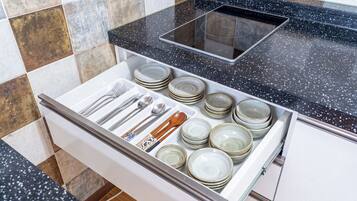 A kitchen drawer with neatly organized utensils and plates.