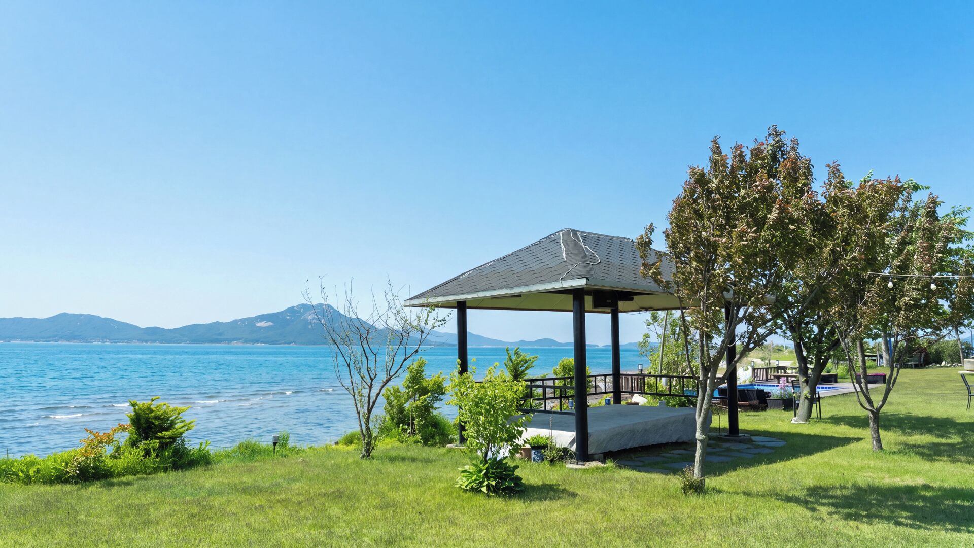 En pavillon med udsigt til havet og bjergene i baggrunden.