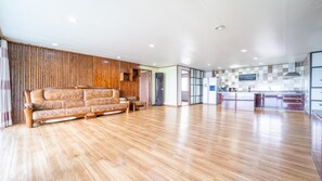 Relax in a spacious living area with a plush leather sofa and adjacent kitchen featuring a modern design.