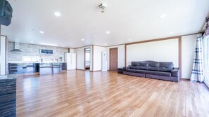 Relax in this spacious living area with a modern kitchen, featuring a sofa, refrigerator, microwave, and stove.