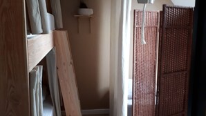 A room with a bunk bed, a hanging light fixture, a potted plant, and a sliding door. - Holiday home, between bay and ocean (Saint-Pierre-Quiberon)