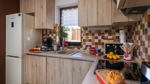 Eine moderne Küche mit Holzausstattung, einer eingebauten Mikrowelle und verschiedenen Küchenutensilien auf der Arbeitsfläche.