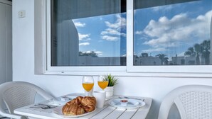 Ein Frühstückstisch mit Croissants, Orangensaft und einer kleinen Pflanze.