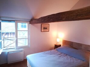 Cozy retreat with a single bed, bedside table, and window offering a view of the outside.
