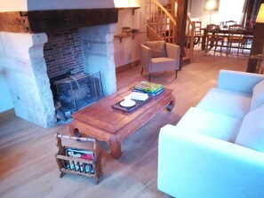 Cozy living room with a brick fireplace, wooden coffee table, and comfortable seating area.