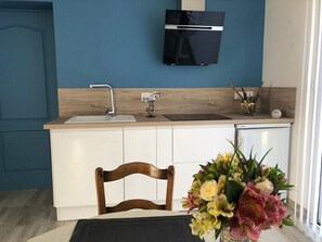 A compact kitchen with a built-in sink, a microwave, and a small refrigerator.