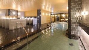Un área de spa con jacuzzi, techo de madera y paredes de piedra.