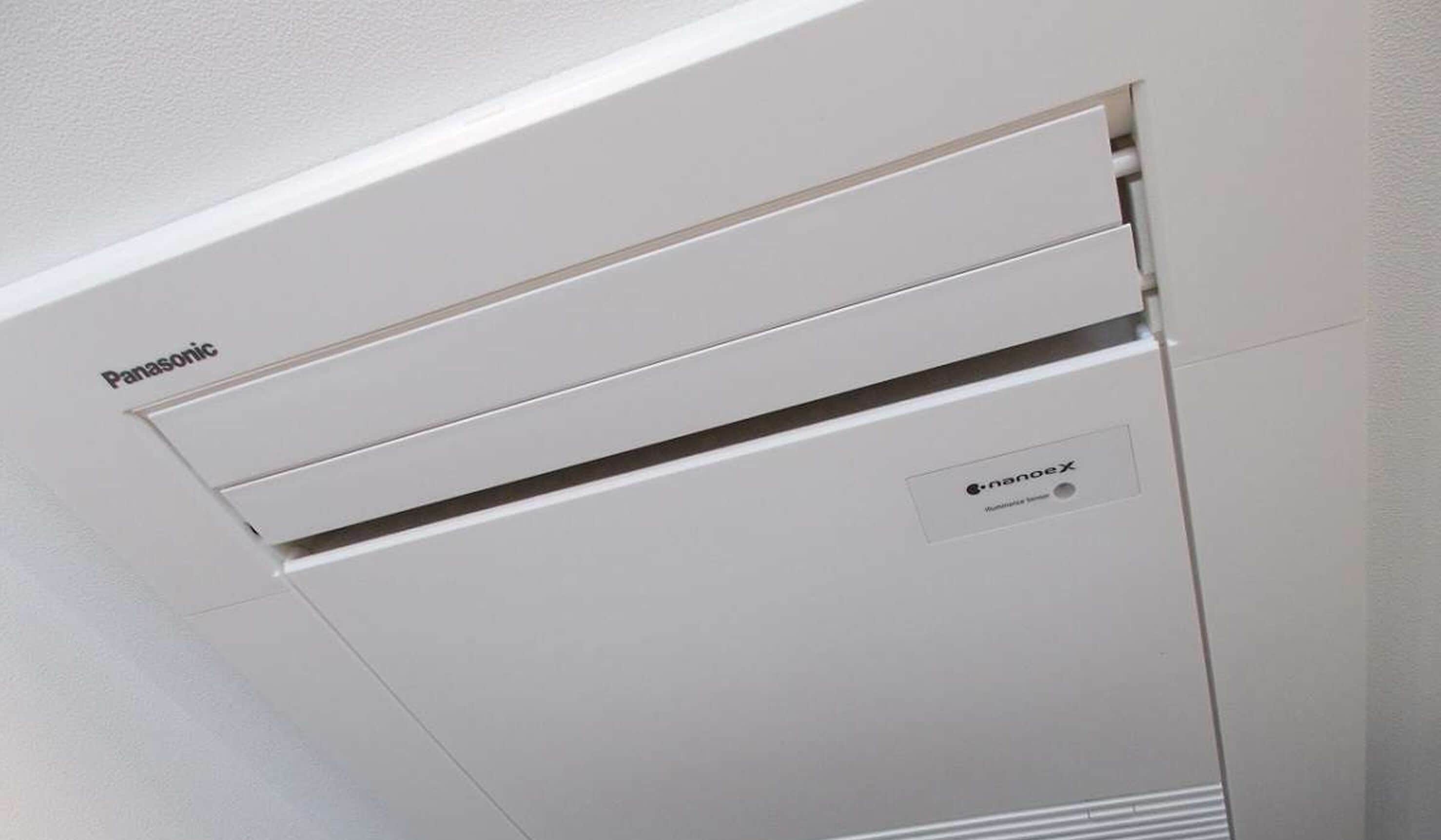 Un equipo de aire acondicionado Panasonic montado en una pared blanca.