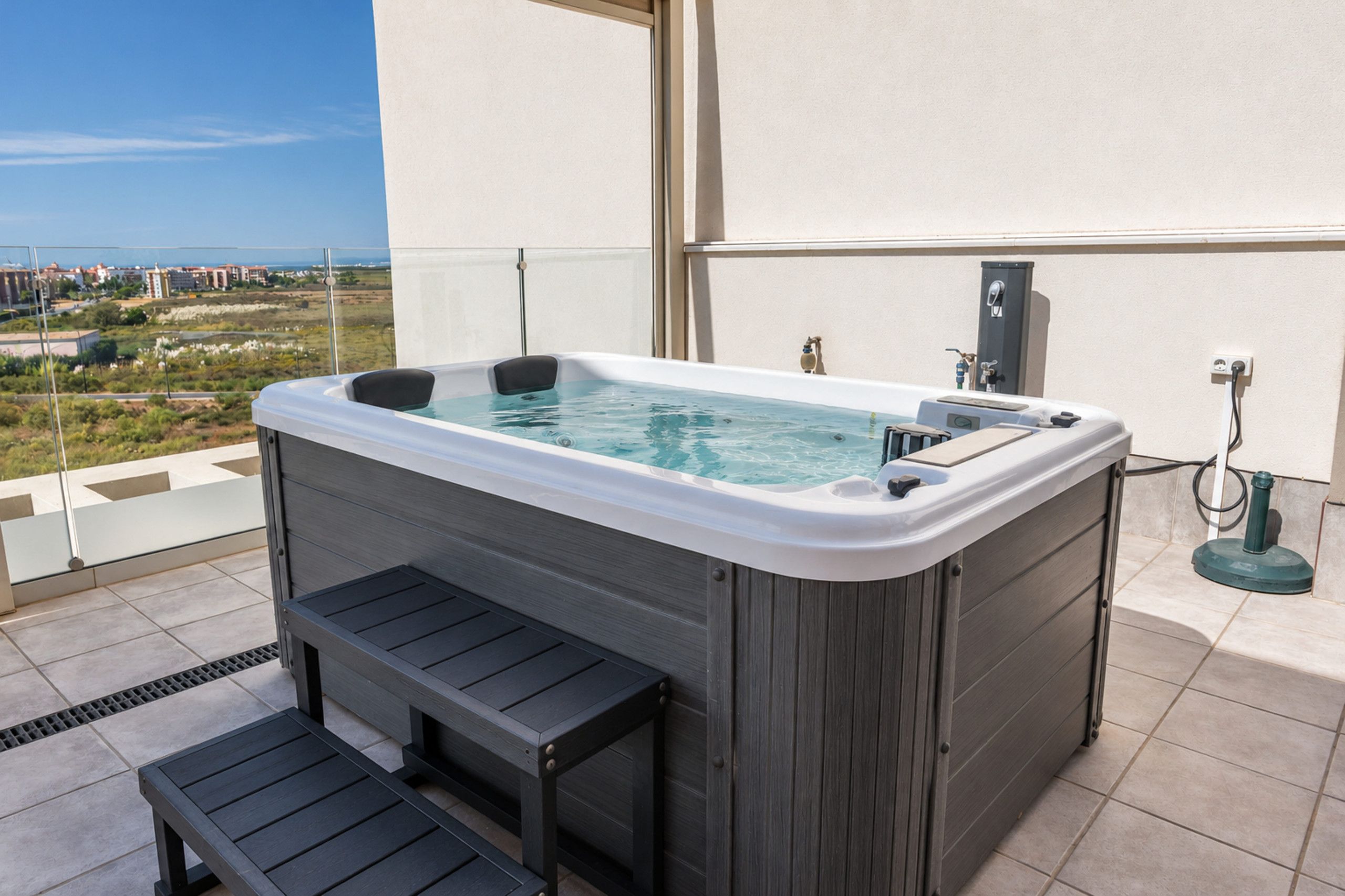 Een bubbelbad op een balkon met uitzicht op de stad.