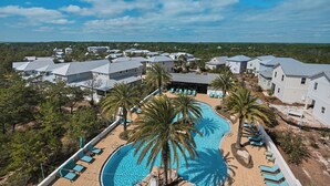 Ein Resort mit großem Pool, Palmen und mehreren Gebäuden im gleichen Baustil.