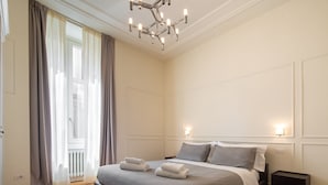 A bedroom with a large bed, a chandelier, and a radiator. - Florence Luxury Apartment al Duomo by Mmega (Florence)