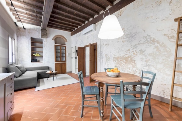 Una habitación con una mesa de comedor, sillas, un sofá y una zona de cocina.