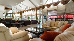 A spacious lobby with leather sofas, a coffee table, and large windows. - Atabay Termal Hotel (Kozakli)
