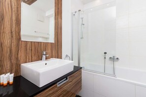 Bathtub, hair dryer, towels, shampoo