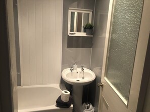 A bathroom with a bathtub, a sink, and a toilet. - Captivating 2-bed Apartment in Isle of Bute (Rothesay)