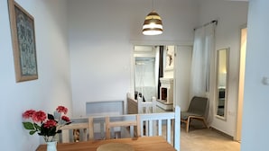Ein Essbereich mit Holztisch und Stühlen, einer Blumenvase und einer Pendelleuchte.
