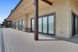 A modern building with a wooden deck, large sliding glass doors, and a table with chairs. - Spacious w/ Amazing View, Large Deck Spacious Open Plan Near Spearfish (Spearfish)