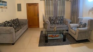 A living room with two sofas, a coffee table, and a ceiling fan. - Luxurious Home (Draxhall)