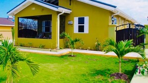A two-story house with a number '200' on the front, a small front yard with palm trees, and a black gate. - Luxurious Home (Draxhall)
