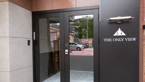 A hotel entrance with a glass door, a metal handle, and a sign reading 'THE ONLY VIEW'. - The Only View (Osaka)