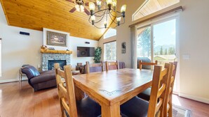 Un salon spacieux avec une table à manger en bois, un canapé en cuir et une cheminée.