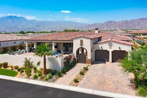 A residential property with a patio, outdoor seating, and a mountain backdrop.