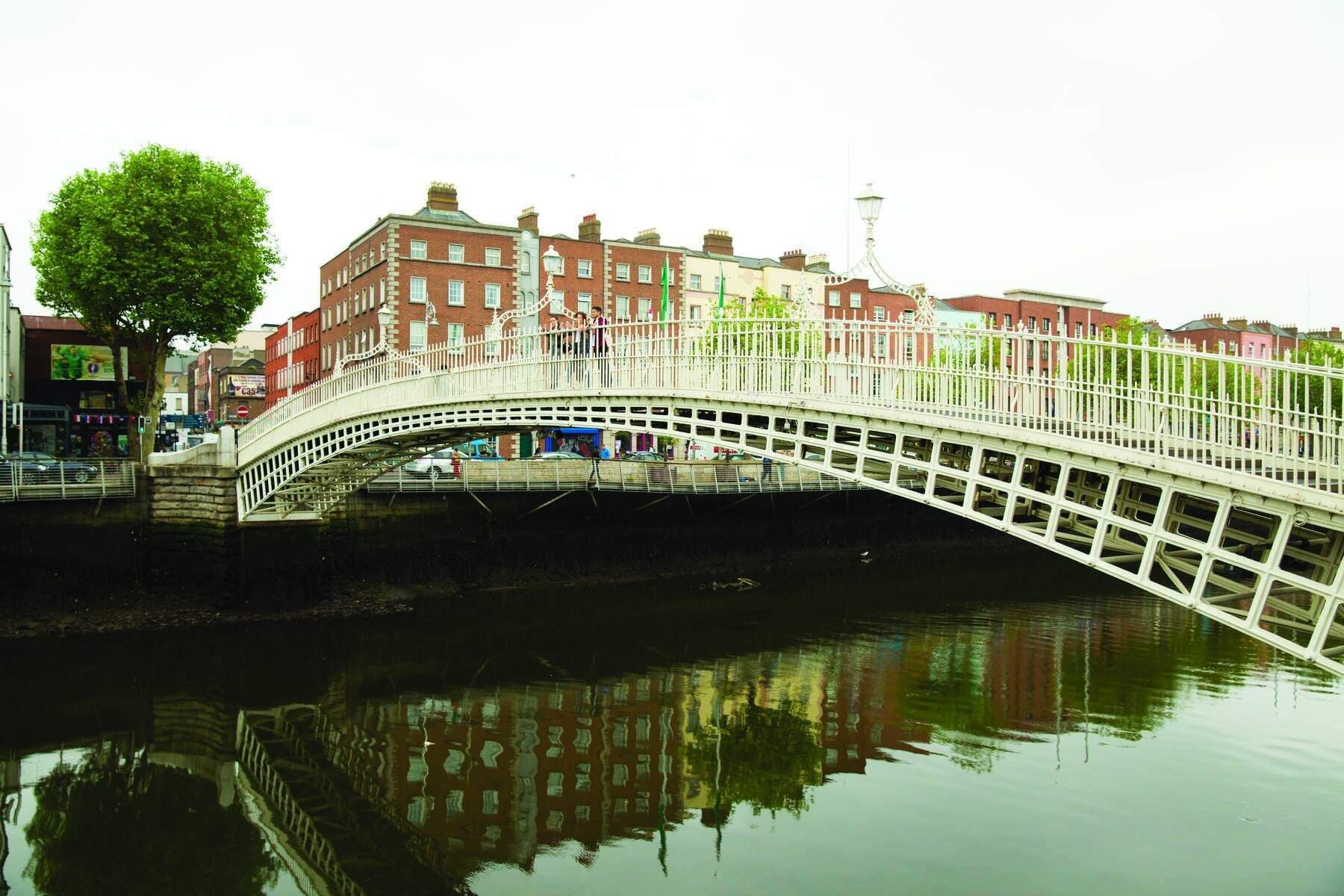 A white bridge over a river with buildings on either side.