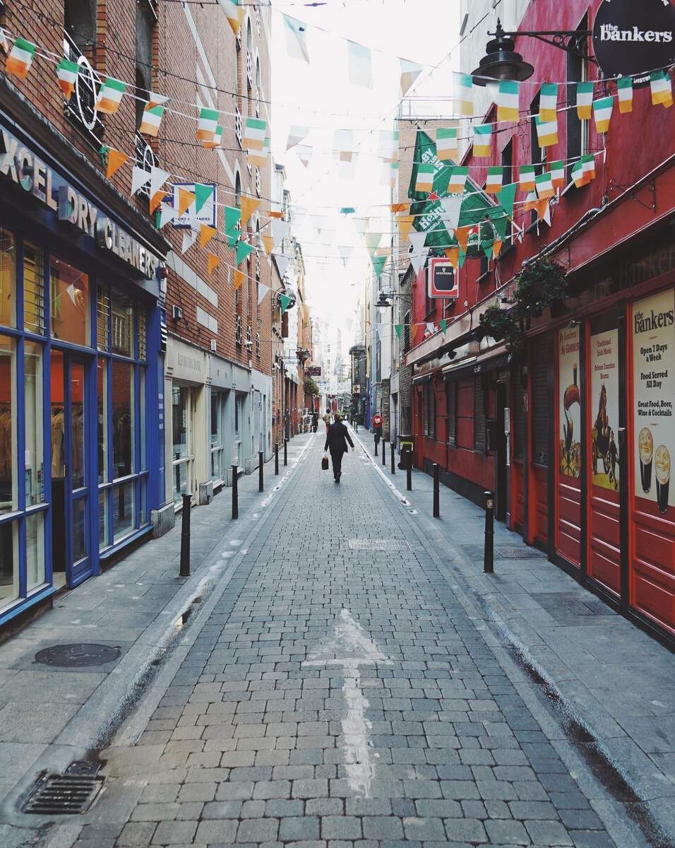 A narrow street lined with shops and a pedestrian walkway.